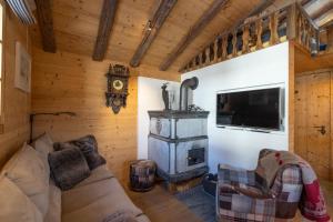 a living room with a couch and a wood stove at Rumpelstilzchen in Bettmeralp +14 photos