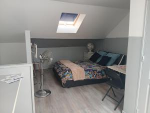 a bedroom with a bed and a desk and a window at Le Trait d'union - Studio César, 2éme Étage in Romilly-sur-Seine