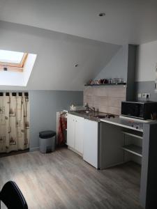 a large kitchen with white cabinets and a window at Le Trait d'union - Studio César, 2éme Étage in Romilly-sur-Seine +4 photos
