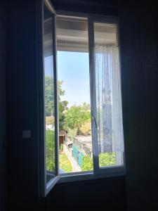 an open window with a view of a yard at Le Trait d'union - Studio César, 2éme Étage in Romilly-sur-Seine