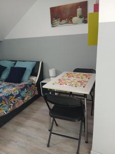 a room with a table and chairs and a bed at Le Trait d'union - Studio César, 2éme Étage in Romilly-sur-Seine