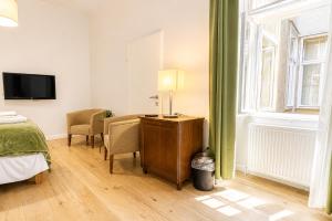 a bedroom with a bed and a desk and a window at 1 Aprt & 5 Stylish Hotel Rooms, Comfort & Convenience Combined in Vienna