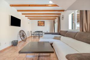 a living room with a couch and a table at Villas2meet Los Geranios in Cala Romàntica