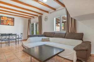 a living room with a couch and a table at Villas2meet Los Geranios in Cala Romàntica