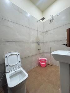 a bathroom with a toilet and a sink at Norway Residency in Jagādhri