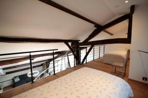 an attic bedroom with a bed and a chair at Maison Camélia in Paliseul