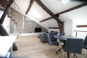 a living room with a staircase and a table and chairs at Maison Camélia in Paliseul