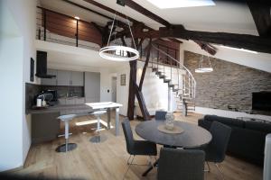 a kitchen and a living room with a table and chairs at Maison Camélia in Paliseul