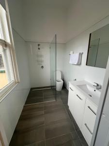 a bathroom with a shower and a toilet and a sink at Branxholm Hotel in Branxholm