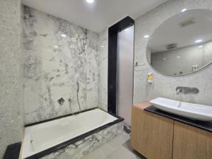a bathroom with a bath tub and a sink at Hotel Asopalav in Junagadh +17 photos