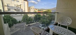 a balcony with two chairs and a view of a city at Hotel Asopalav in Junagadh