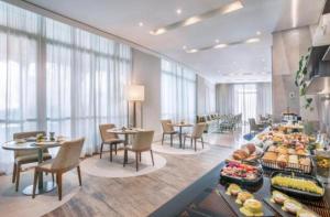 a hotel lobby with tables and chairs and a buffet at Hotel ML Jardim Europa Itaim UH-303 in São Paulo
