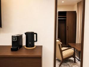 a coffee maker on a desk in a hotel room at Alsharafh room 3 in Sayq