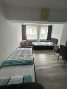a dorm room with two beds and two windows at Ferienwohnung Erna in Marktoberdorf