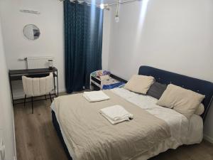 a bedroom with a bed with two towels on it at Havre de paix confort,élégance in Chelles