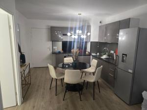 a kitchen with a dining room table and chairs at Havre de paix confort,élégance in Chelles