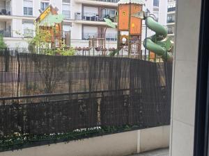 a black fence with a playground in front of a building at Havre de paix confort,élégance in Chelles