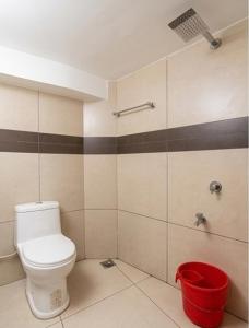 a bathroom with a toilet and a red bucket at Vayal Heritage Villa in Angamaly