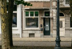 een winkelpui met een groene deur en een raam bij Hotel Vrythof - just a room - digital key by email or SMS in Maastricht