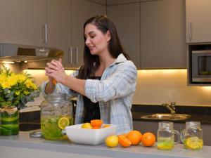 a woman standing in a kitchen preparing food at Adagio Doha in Doha