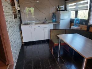 a kitchen with a table and a sink and a refrigerator at Kućica Dva Dječaka in Ulcinj