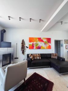 a living room with a black couch and a painting at Landidyll am Bauerhof in Sankt Valentin