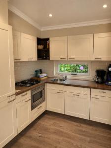 a kitchen with white cabinets and a sink and a window at BLUE BEACH HOUSE in Breskens