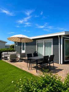 a patio with a table and chairs and an umbrella at BLUE BEACH HOUSE in Breskens