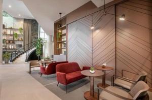 a lobby with red chairs and tables and a staircase at Hotel ML Jardim Europa Itaim UH-303 in São Paulo