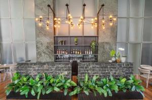 a lobby with a bar with a bunch of plants at Hotel ML Jardim Europa Itaim UH-303 in São Paulo