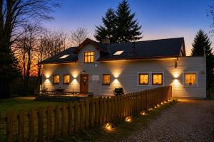 a white house with lights on the side of it at U krbu in Jindřichovice