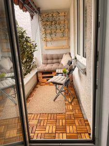 a balcony with a couch and a chair on a porch at Little Royal in Garbsen