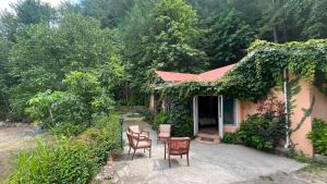 a house with two chairs and a table in front of it at Escape cottage Nathia Gali 