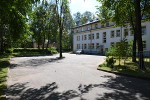 a parking lot in front of a white building at Hotel Vilmaja in Riga