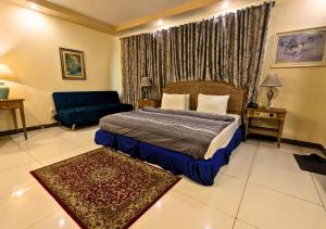 a hotel room with a bed and a couch and a bed and a couch at Hotel New Panorama in Lahore