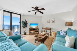 a living room with a blue couch and a ceiling fan at Aquavista 304W in Panama City Beach