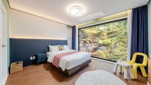 a bedroom with a bed and a large window at Wonju Healing Forest in Wonju +4 photos
