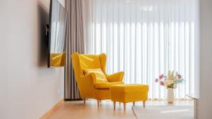 a living room with a yellow chair and a vase of flowers at Wonju Healing Forest in Wonju