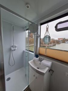a bathroom with a sink and a shower and a window at Hafensuite In Templin Uckermark in Templin