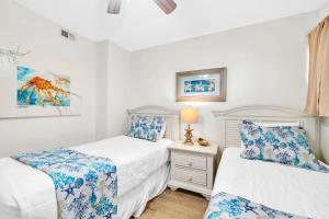 a bedroom with two beds and a lamp on a night stand at Aquavista 304W in Panama City Beach +37 photos