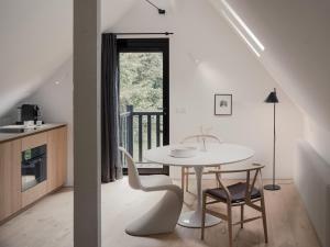a white dining room with a table and chairs at Het Wagenhuis bij Het Witte Kasteel in Loon op Zand