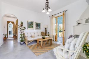 a living room with a white couch and a table at Amaranthos Garden Retreat in Skopelos Town
