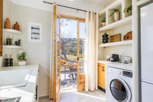 a kitchen with a washer and dryer at Amaranthos Garden Retreat in Skopelos Town +12 photos
