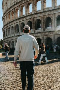 a man walking in front of the coliseum at Hotel Infinity San Pietro in Rome