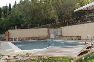 a swimming pool with two lawn chairs next to it at Hotel Sor Paolo in San Casciano in Val di Pesa