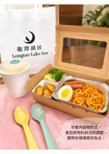 a lunch box with a box of food and spoons at Longtan Lake Inn in Jiaoxi