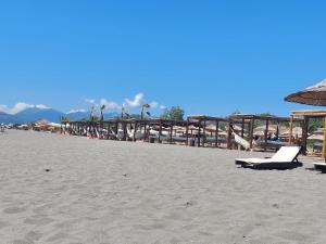 a beach with chairs and umbrellas on the sand at Apartman Dva Dječaka in Ulcinj