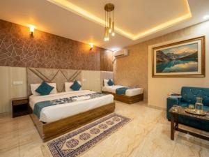 a hotel room with two beds and a couch at Hotel De - Grand Villa Near Delhi IGI Airport in New Delhi