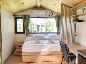 a bedroom with a bed and a desk and a window at InPlai Cabins in Albestii de Arges