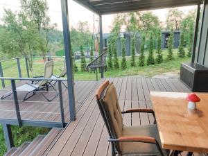 a wooden deck with a table and chairs and a table and a table at InPlai Cabins in Albestii de Arges